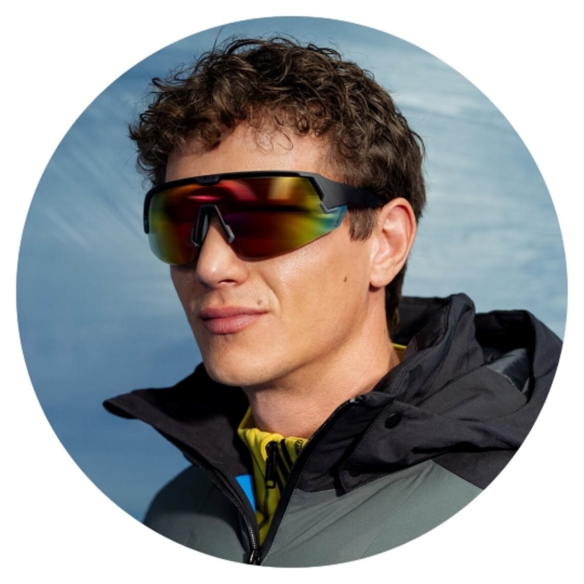 Man wearing shield sunglasses with multicoloured mirrored lenses.